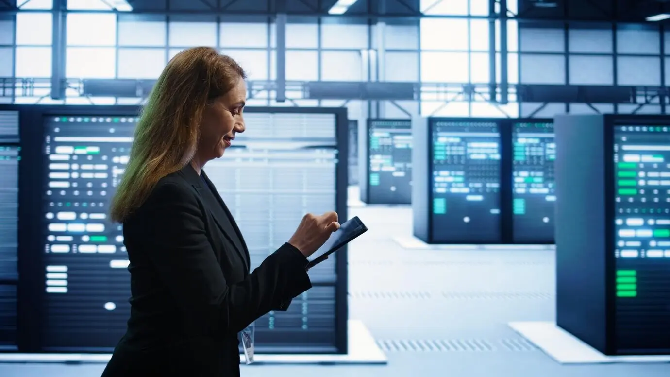 Техник проводит ежегодную проверку с помощью планшета для сохранения электроники дата-центра.